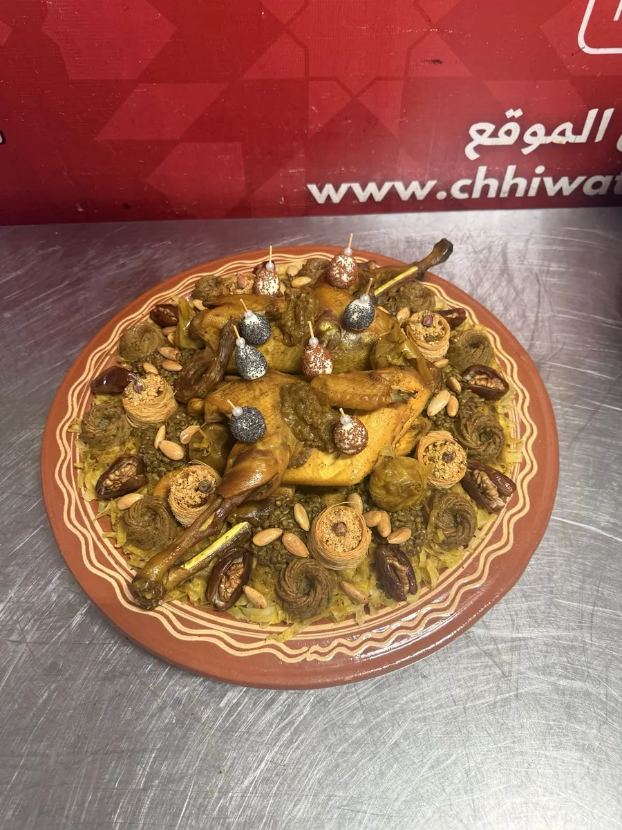 Family rfissa platter with chicken and lentils served in an earthenware dish